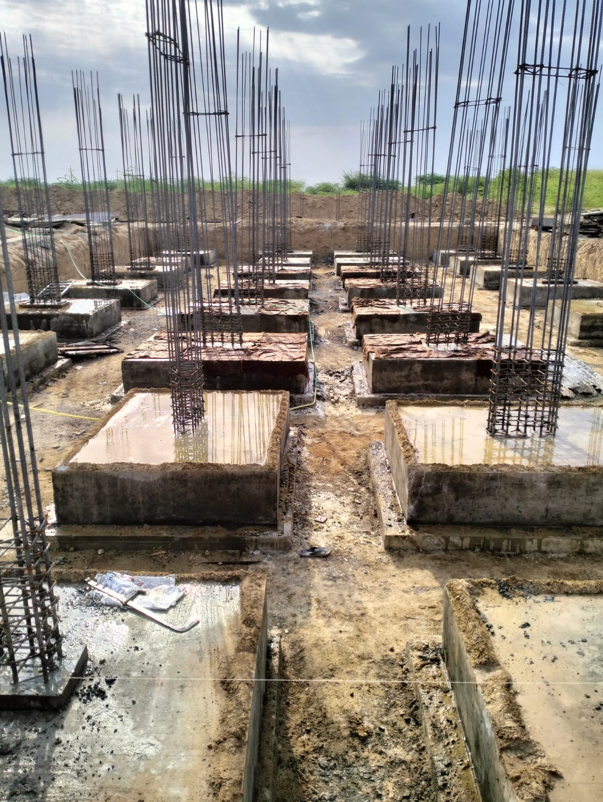Rows of concrete footings with vertical reinforcement cages
