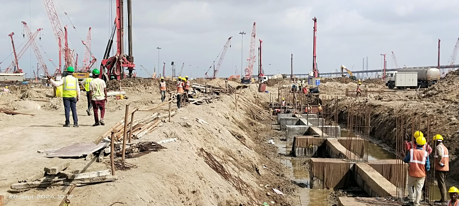 Foundation blocks and reinforcement beside a line of piling rigs